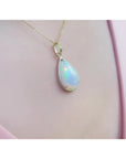 Radiant 9.29 ct. Ethiopian Welo opal pendant in 14K solid yellow gold, worn on a pink top.