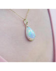 Radiant 9.29 ct. Ethiopian Welo opal pendant in 14K solid yellow gold, worn on a pink top.