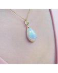 Radiant 9.29 ct. Ethiopian Welo opal pendant in 14K solid yellow gold, worn on a pink top.