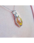 Opal pendant necklace on a light pink skin background.