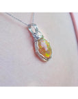Ethiopian opal pendant with vibrant play of colors and brown pinpoint fire, set in a silver wire wrap.