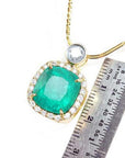 Cushion cut emerald necklace in 18K yellow gold with diamond halo, shown with a ruler for scale.