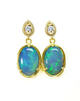 Bluish-green Australian opal earrings with dangling diamonds set in 14K yellow gold.