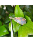 4.30 ct Australian opal pendant with fiery red-orange flashes, halo diamonds, 18K yellow gold, on green leaves.