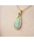 Opal pendant necklace on a person's neck against a neutral background