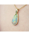 Opal pendant necklace on a person's neck against a neutral background