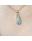 Opal pendant necklace on a gold chain worn by a person