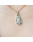 Opal pendant necklace on a gold chain worn by a person