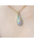 4.30 ct. solid Australian opal pendant with fiery red-orange flashes, halo diamonds, and 18K yellow gold chain.