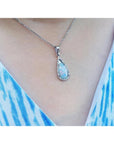 Pear-shaped Australian white opal pendant with red-orange play of color, set in 18k white gold on a silver chain.