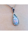 Teardrop-shaped opal pendant on a chain against a skin background.