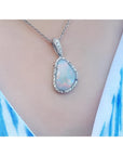 Solid Australian opal pendant with red/orange flashes, halo diamonds, and 18K white gold chain.