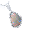 A solid Australian opal pendant in white gold with diamond accents on a white background