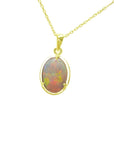 Oval Australian opal pendant with red and green fire, set in 14k yellow gold on a delicate chain.