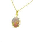 Oval Australian opal pendant with red and green fire, set in 14k yellow gold on a delicate chain.