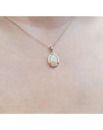 Necklace with an opal pendant on a person's neck