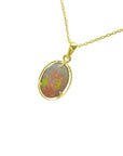 Opal pendant necklace on a gold chain against a white background