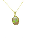 Oval Australian opal pendant with vibrant green and red play-of-color, set in 14k yellow gold on a delicate chain.