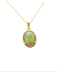 Oval Australian opal pendant with vibrant green and red play-of-color, set in 14k yellow gold on a delicate chain.