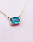 Besel set Emerald solitaire necklaces for sale east-west orientation handcrafted in 18k yellow gold