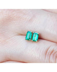 Pair of emerald cut emerald stud earrings, 0.78 ct, in 14K yellow gold basket settings.