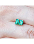 Pair of emerald cut emerald stud earrings, 0.78 ct, in 14K yellow gold basket settings.