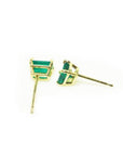Pair of emerald cut emerald stud earrings in 14K yellow gold basket settings with push backs.