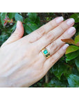 1.53 ct. square emerald solitaire ring in 18K yellow gold with a bezel setting on a hand.