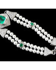 Pearl bracelet with emerald and diamond accents on a black background