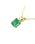 Gold necklace with a natural colombian emerald pendant on a left-side position topside view.