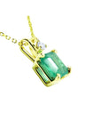 Gold pendant with a genuine colombian emerald on its right-side position, top and gallery visibles.