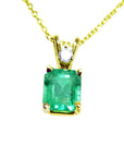 This natural emerald-cut colombian emerald pendant made of yellow gold is showing its topside.