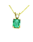 This natural emerald-cut colombian emerald pendant made of yellow gold is showing its topside.