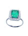 Radiant emerald-cut bluish-green emerald ring with halo diamonds in 14K white gold.