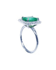 Emerald-cut emerald ring with halo diamonds in 14K white gold.