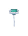 Emerald-cut bluish-green emerald ring with halo diamonds in 14K white gold.