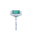 Emerald-cut bluish-green emerald ring with halo diamonds in 14K white gold.