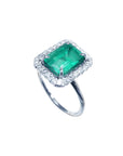 Emerald-cut bluish-green emerald ring with halo diamonds in 14K white gold.