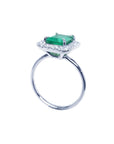 Emerald-cut emerald ring with halo diamonds in 14K white gold.