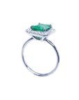 Emerald-cut emerald ring with halo diamonds in 14K white gold.