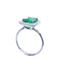 Emerald-cut emerald ring with halo diamonds in 14K white gold.