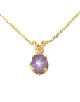 This natural star pink sapphire pendant necklace shows its asterisk under a LED bulb light and it is made of 14kgold.