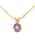 This natural star pink sapphire pendant necklace shows its asterisk under a LED bulb light and it is made of 14kgold.