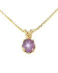 This natural star pink sapphire pendant necklace shows its asterisk under a LED bulb light and it is made of 14kgold.