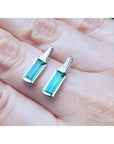 2.00 ct natural baguette emerald stud earrings in 14k white gold with diamond accents.