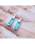 2.00 ct natural baguette emerald stud earrings in 14k white gold with diamond accents.