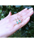 14K gold stud emerald leaf earrings with vibrant rectangular green emeralds and diamonds.