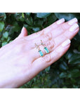 14K gold stud emerald leaf earrings with vibrant rectangular green emeralds and diamonds.
