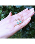 14K gold stud emerald leaf earrings with vibrant rectangular green emeralds and diamonds.