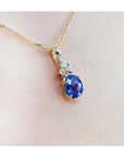 14K yellow gold pendant with oval tanzanite and three diamonds on a delicate chain.
